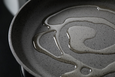Photo of Cooking oil in frying pan on stove, closeup