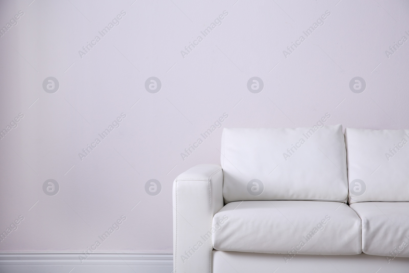 Photo of Simple living room interior with comfortable sofa near white wall. Space for text