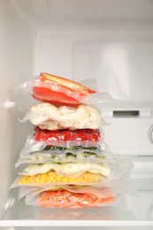Photo of Vacuum bags with different vegetables in fridge. Food storage