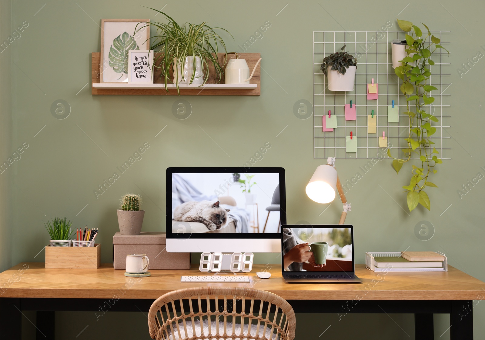 Photo of Stylish workplace with computer, laptop and lamp near olive wall at home