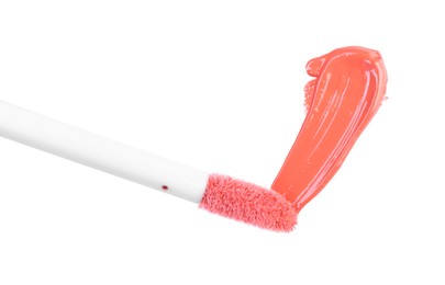 Photo of Stroke of color lip gloss and applicator isolated on white, top view