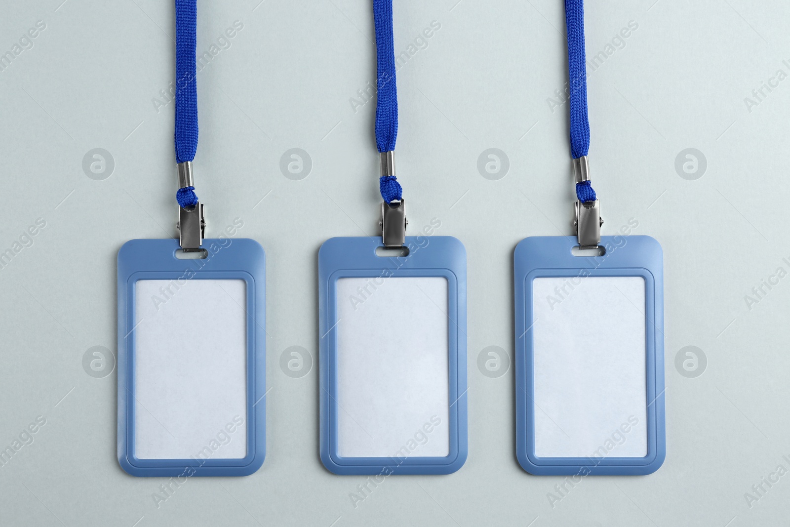 Photo of Blank badges on light background, flat lay. Mockup for design