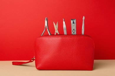 Manicure set in red bag on beige table