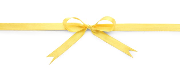 Yellow satin ribbon with bow on white background, top view