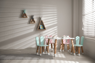 Small table and chairs with bunny ears indoors. Children's room interior