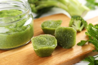 Photo of Frozen broccoli puree cubes and fresh broccoli on cutting board