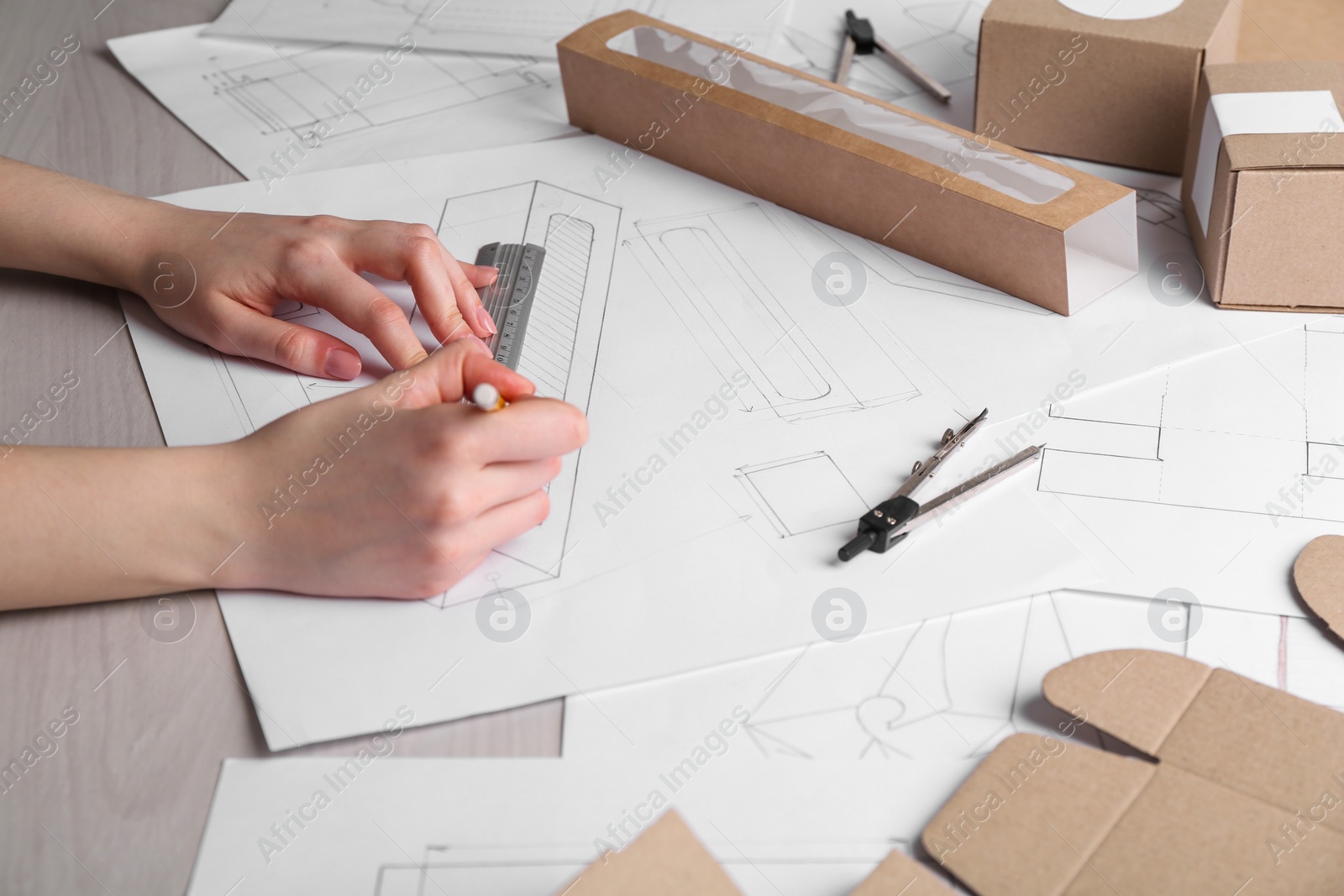 Photo of Woman creating packaging design at table, closeup