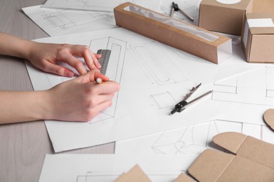 Woman creating packaging design at table, closeup