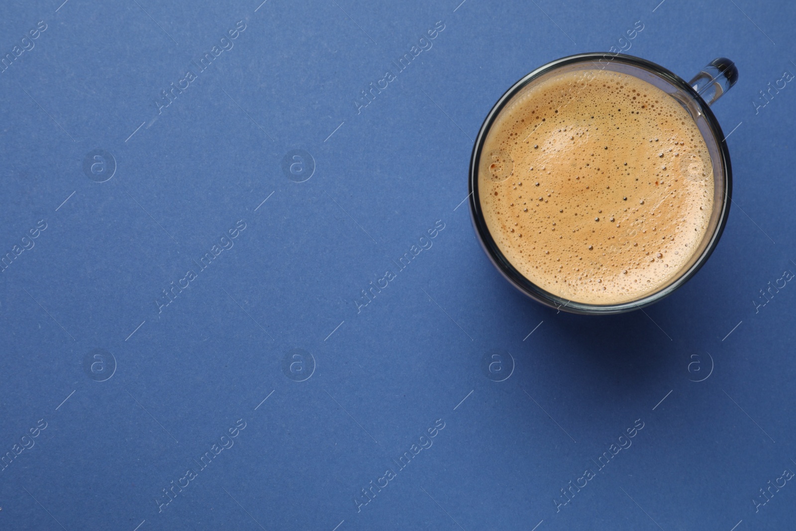 Photo of Fresh coffee in cup on blue background, top view. Space for text