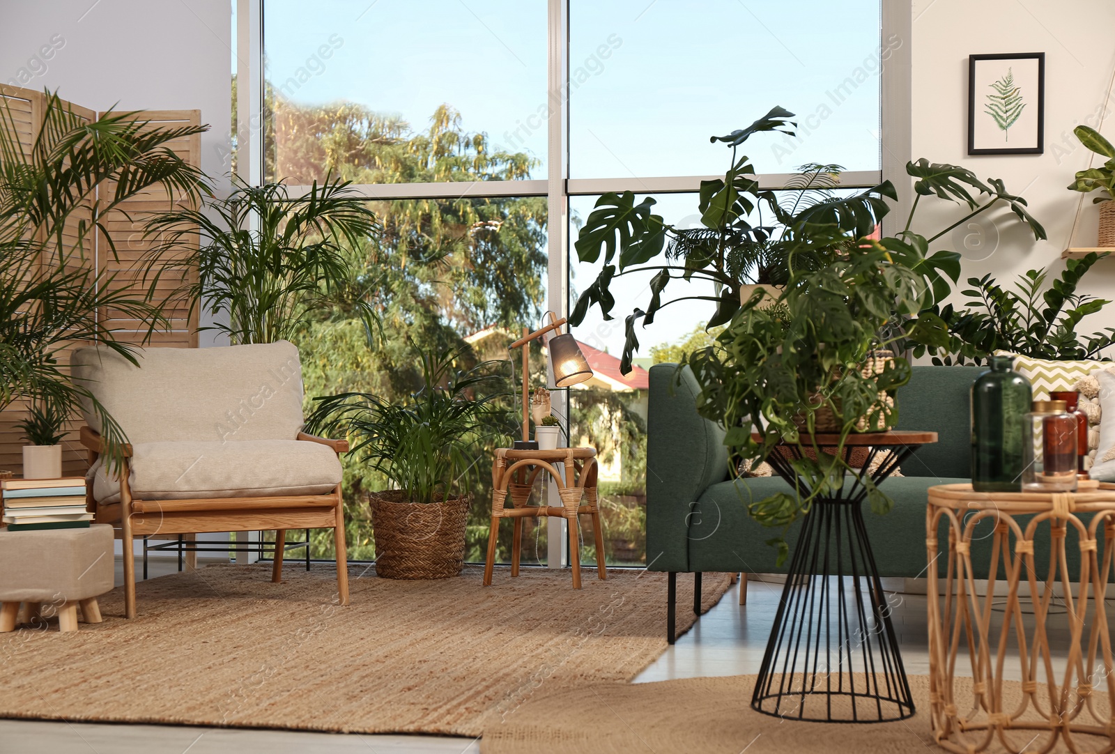 Photo of Stylish room interior with comfortable furniture and different exotic houseplants