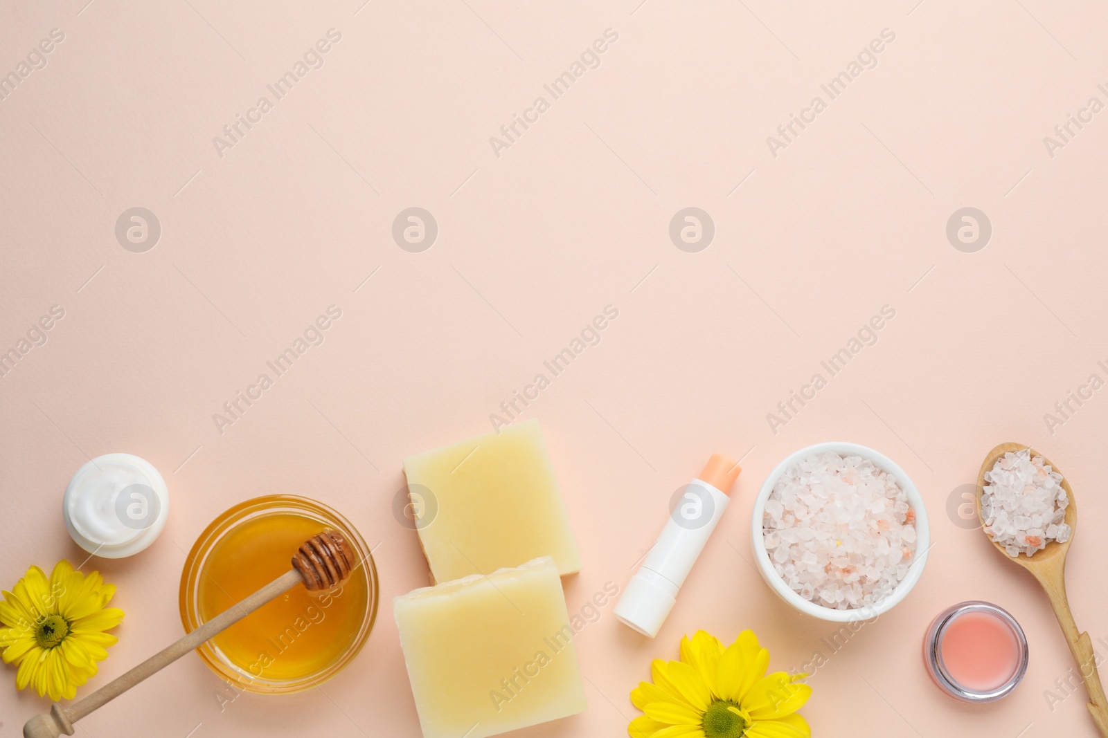 Photo of Flat lay composition with beeswax and cosmetic products on beige background. Space for text