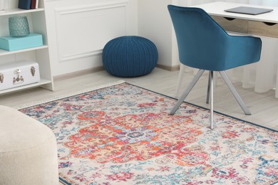 Photo of Stylish rug, armchair and table in room. Interior design