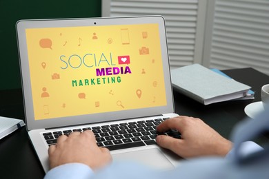 SMM (Social Media Marketing) concept. Man using modern laptop at table, closeup