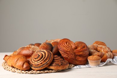 Different tasty freshly baked pastries on white wooden table