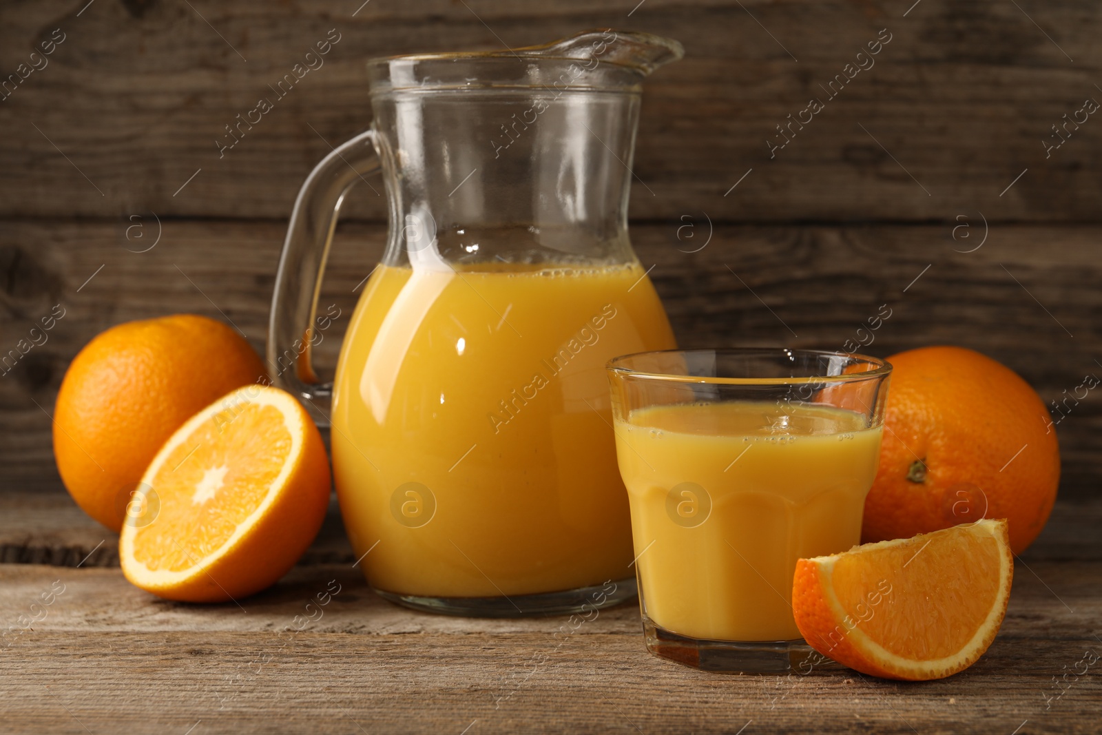 Photo of Tasty fresh oranges and juice on wooden table