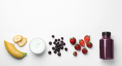 Bottle of acai drink and ingredients on white background, top view