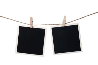 Photo of Clothespins with empty instant frames on string against white background. Space for text
