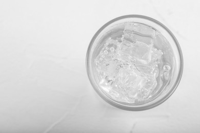 Photo of Glass of soda water on white table, top view. Space for text