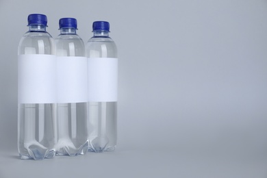Photo of Plastic bottles with soda water on light background. Space for text