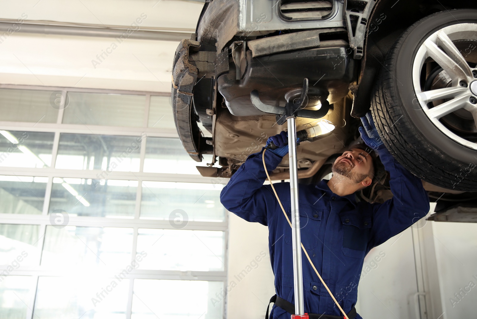 Photo of Technician checking modern car at automobile repair shop