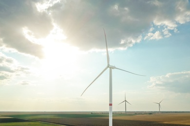 Modern windmill against sky with clouds. Energy efficiency