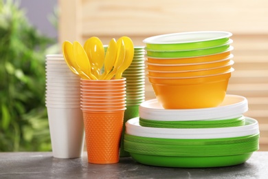 Photo of New plastic dishware on table against blurred background. Table setting