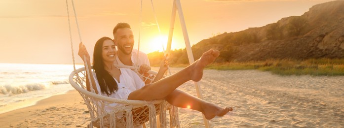 Image of Happy young couple on beach at sunset. Banner design