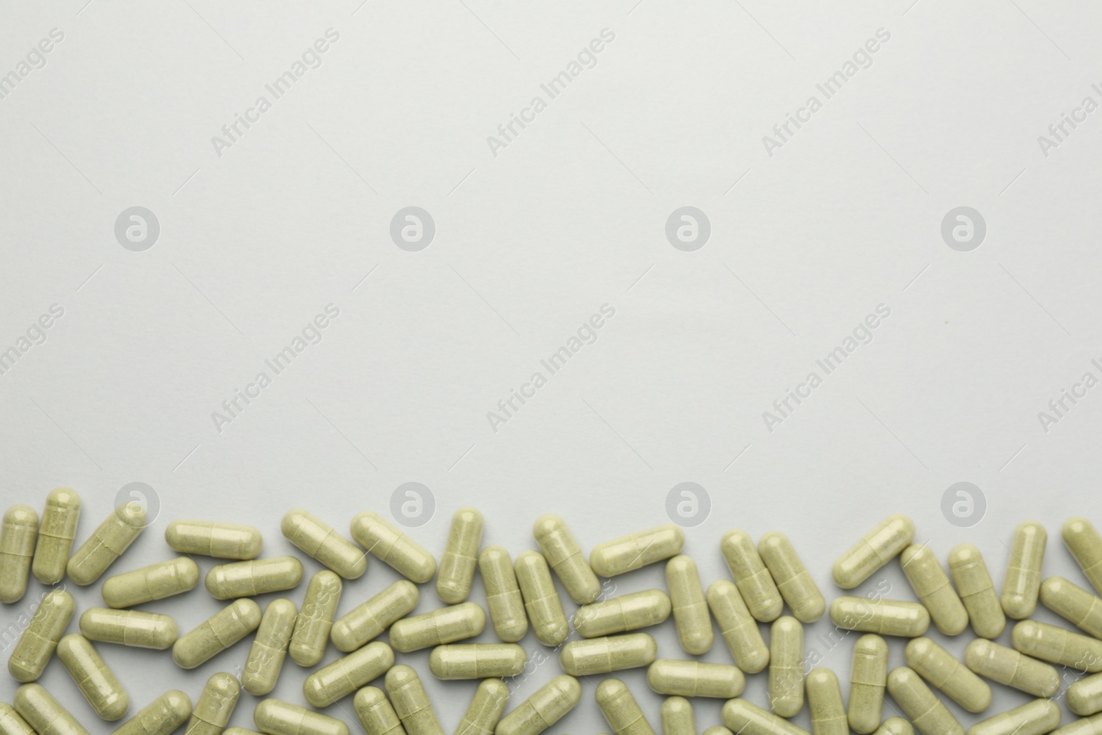 Photo of Vitamin capsules on light grey background, top view and space for text. Health supplement