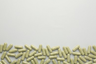 Photo of Vitamin capsules on light grey background, top view and space for text. Health supplement