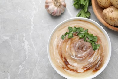 Delicious cream soup with soy sauce and parsley on light grey marble table, flat lay. Space for text