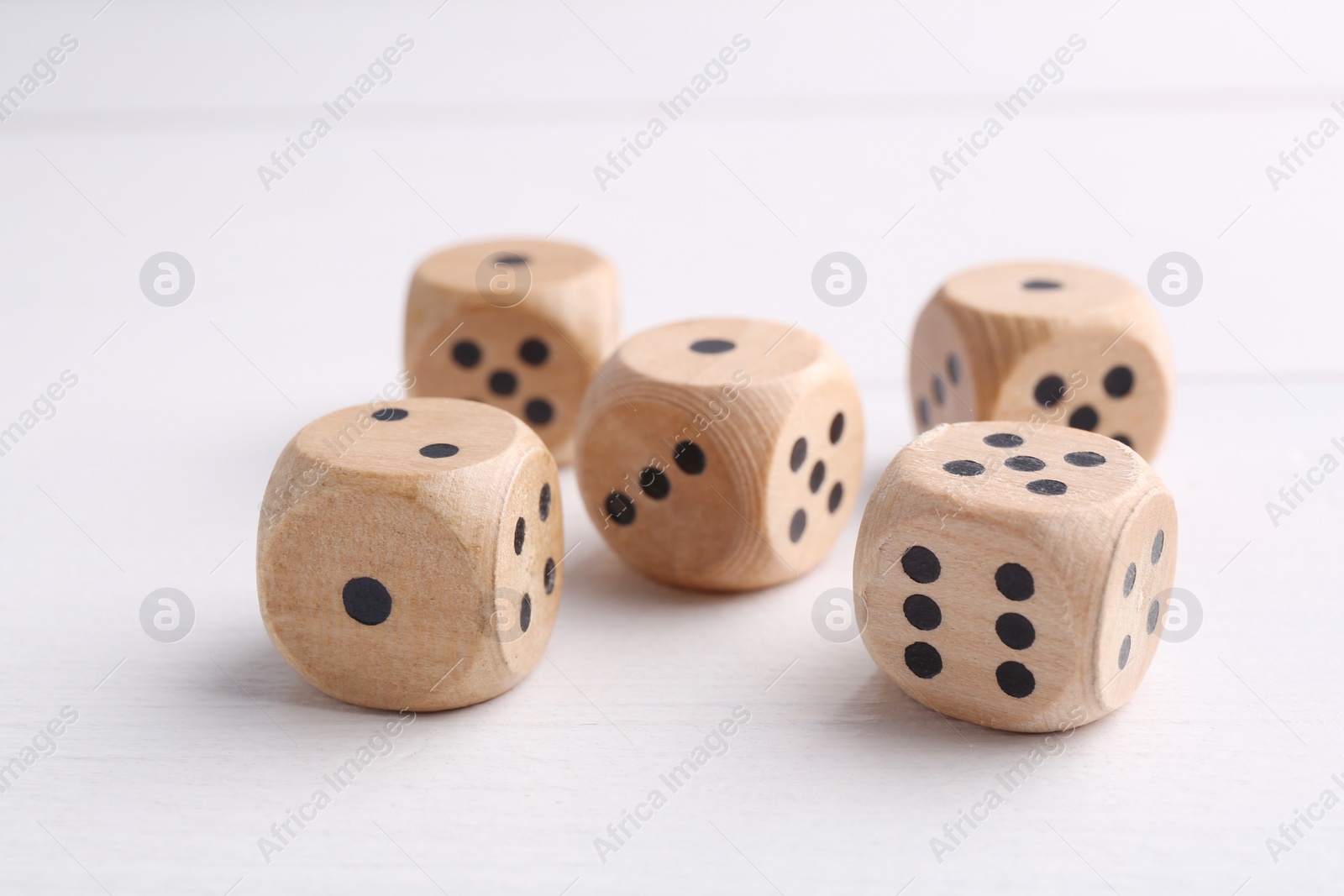 Photo of Many game dices on white wooden table, closeup