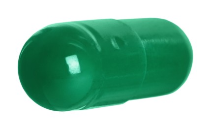 Photo of One green pill on white background. Medicinal treatment