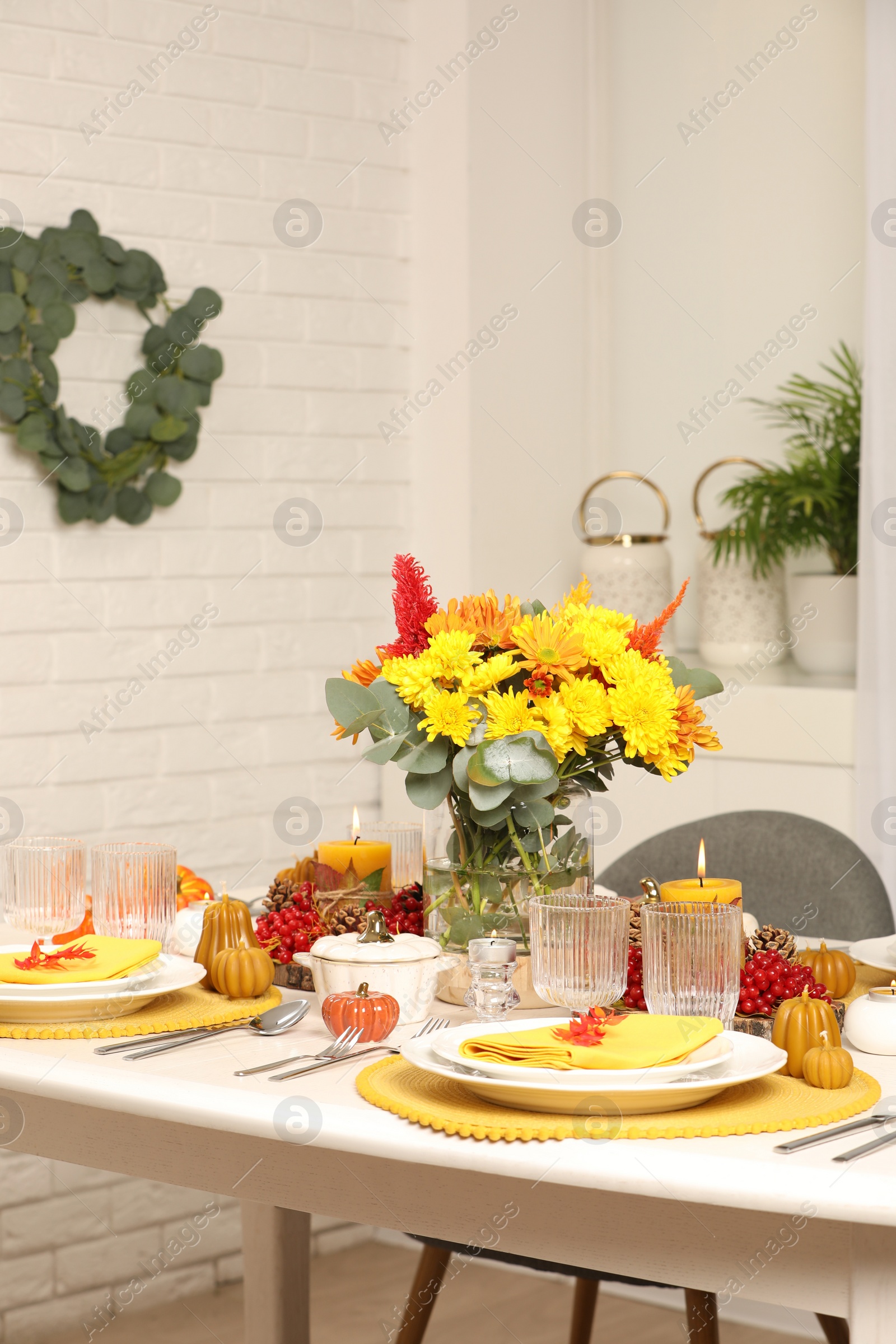 Photo of Autumn table setting with floral decor and pumpkins indoors