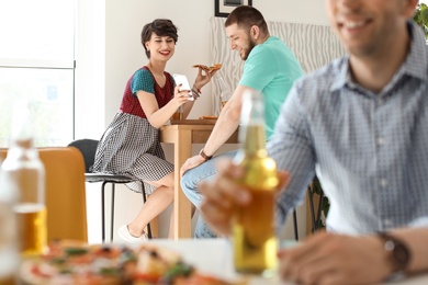 Photo of Young people having fun party with delicious pizza indoors