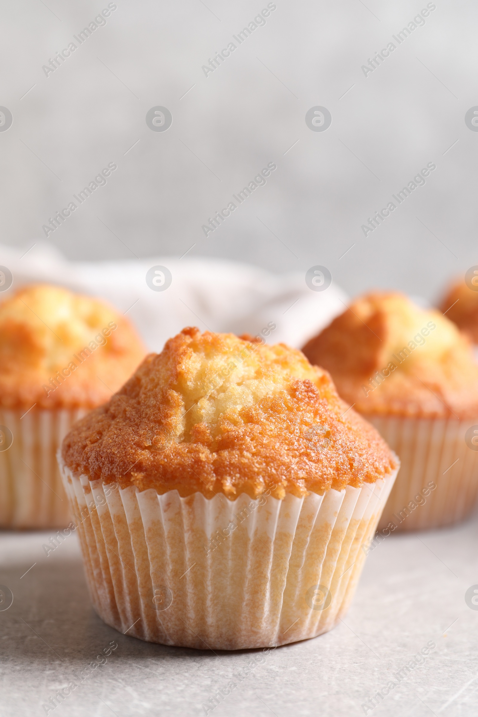 Photo of Tasty muffins on light grey table, closeup. Fresh pastry