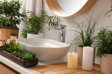 Photo of Counter with sink and many different houseplants near white marble wall