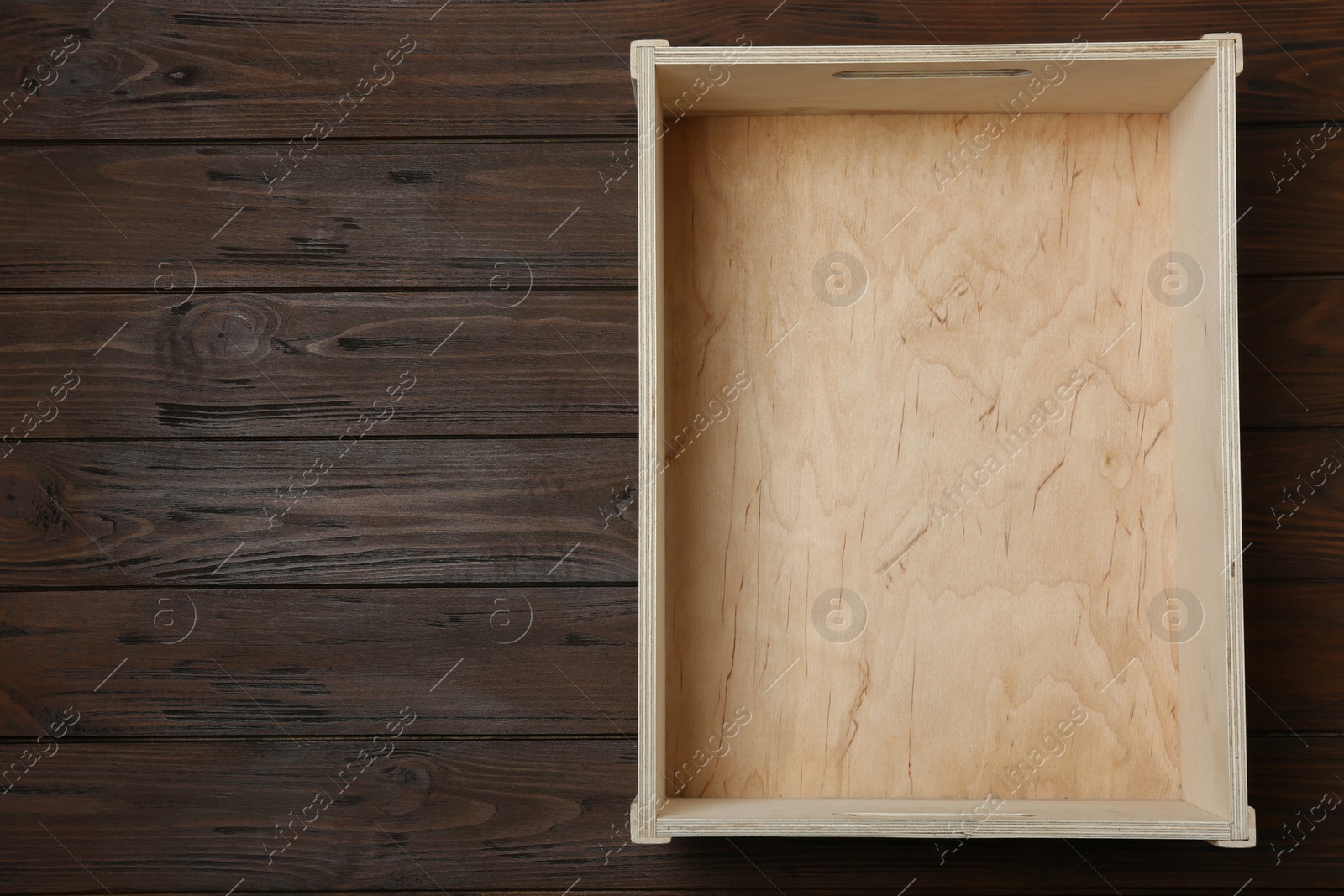 Photo of Empty crate on wooden background, top view with space for text