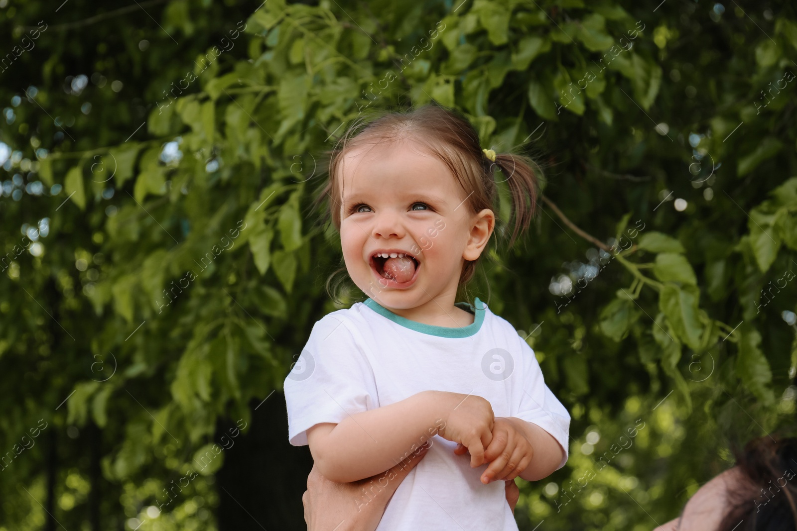 Photo of Mother with her cute daughter in park, closeup