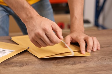 Photo of Post office worker with adhesive paper bag at counter indoors, closeup
