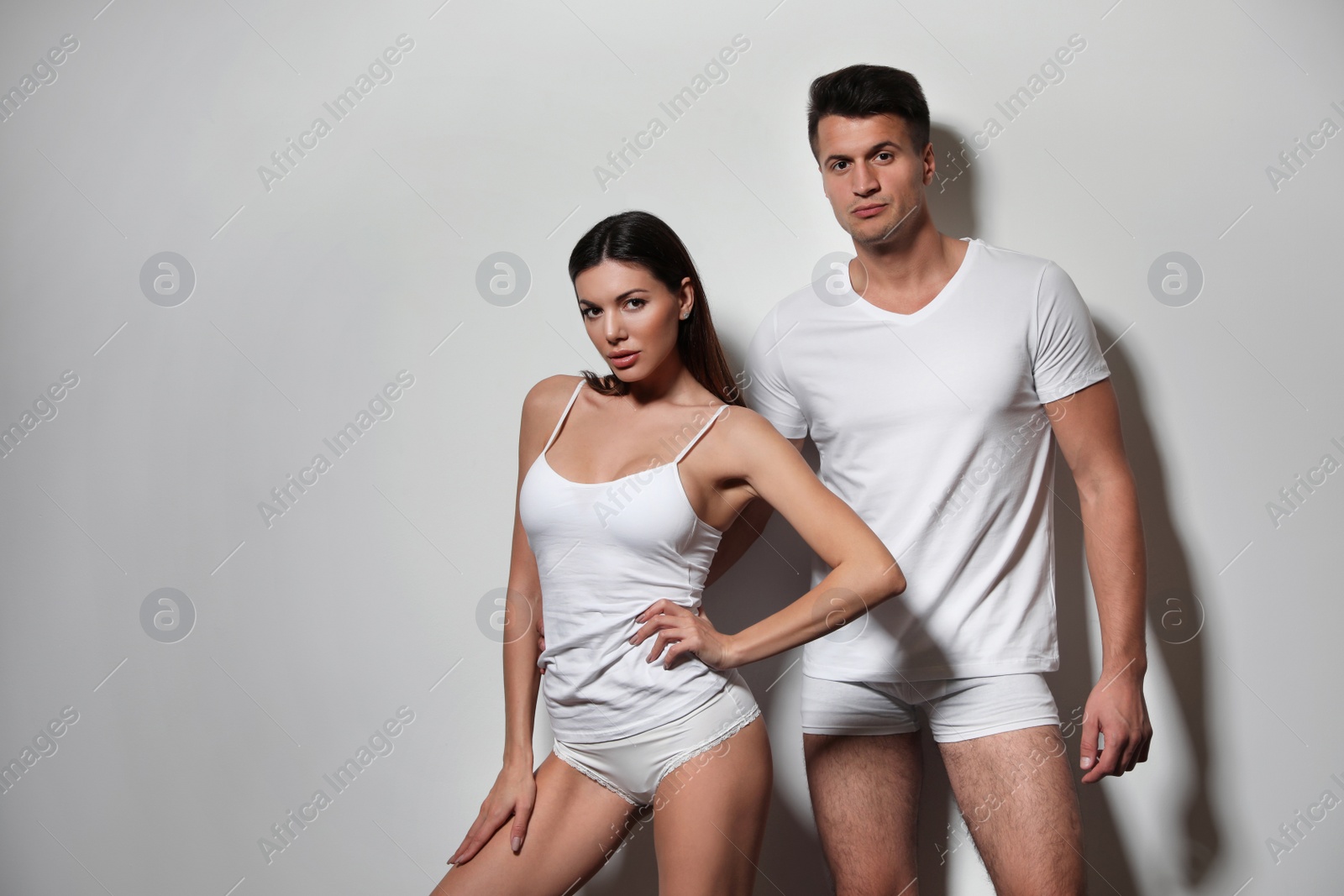 Photo of Young couple wearing underwear on light grey background