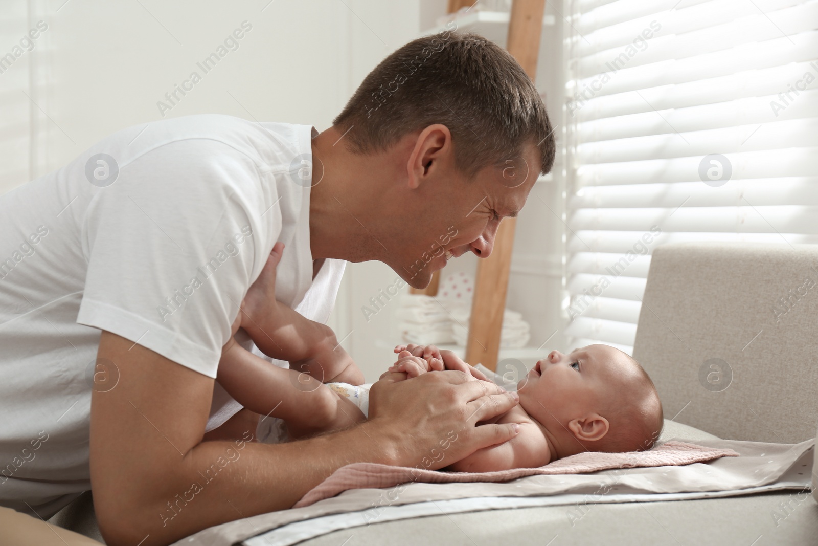 Photo of Happy father with his little baby at home