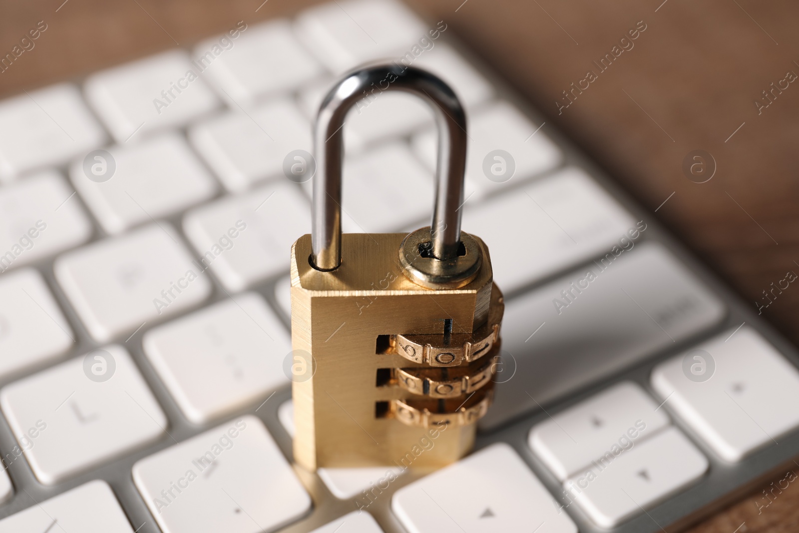 Photo of Cyber security. Keyboard with padlock on table, closeup