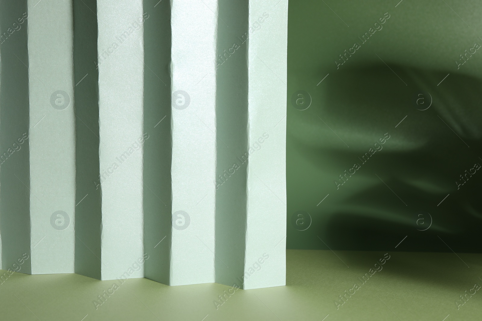 Photo of Presentation of product. Paper and shadows on light green background. Space for text