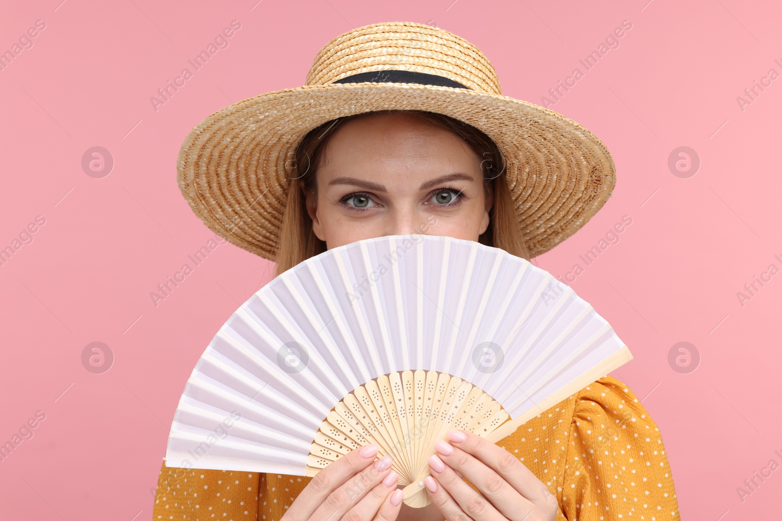 Photo of Woman with hand fan on pink background