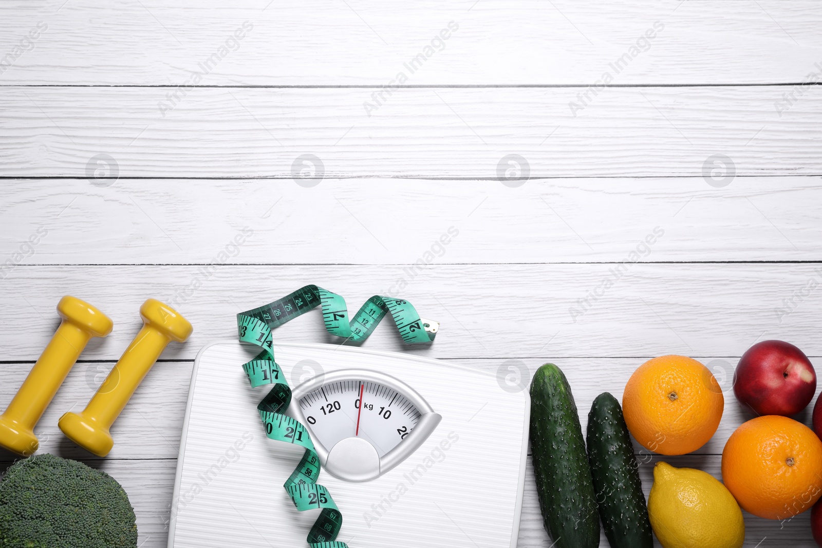 Photo of Scales, measuring tape, fresh fruits and vegetables on white wooden table, flat lay with space for text. Low glycemic index diet