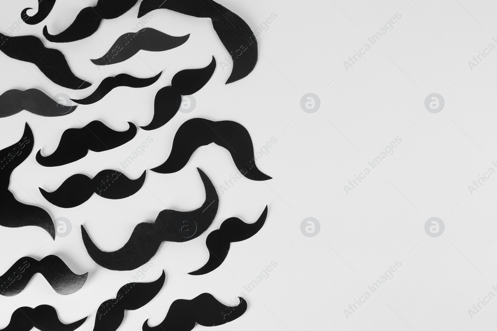 Photo of Fake paper mustaches on light background, flat lay. Space for text