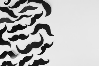 Fake paper mustaches on light background, flat lay. Space for text
