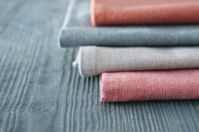 Photo of Different colorful napkins on wooden table, closeup. Space for text