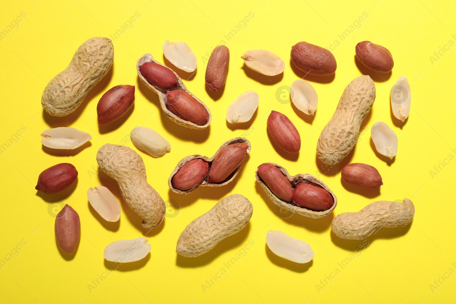 Photo of Fresh peanuts on yellow background, flat lay
