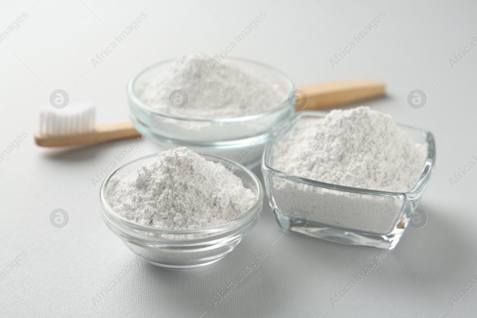 Photo of Tooth powder and brush on white background